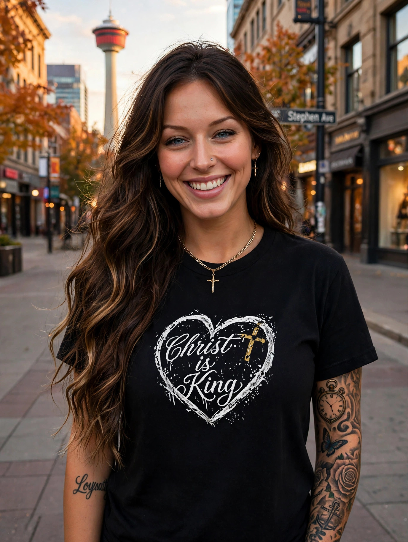 Jelah laughing on Stephen Avenue wearing the Christ Is King heart tee, the Calgary Tower behind her