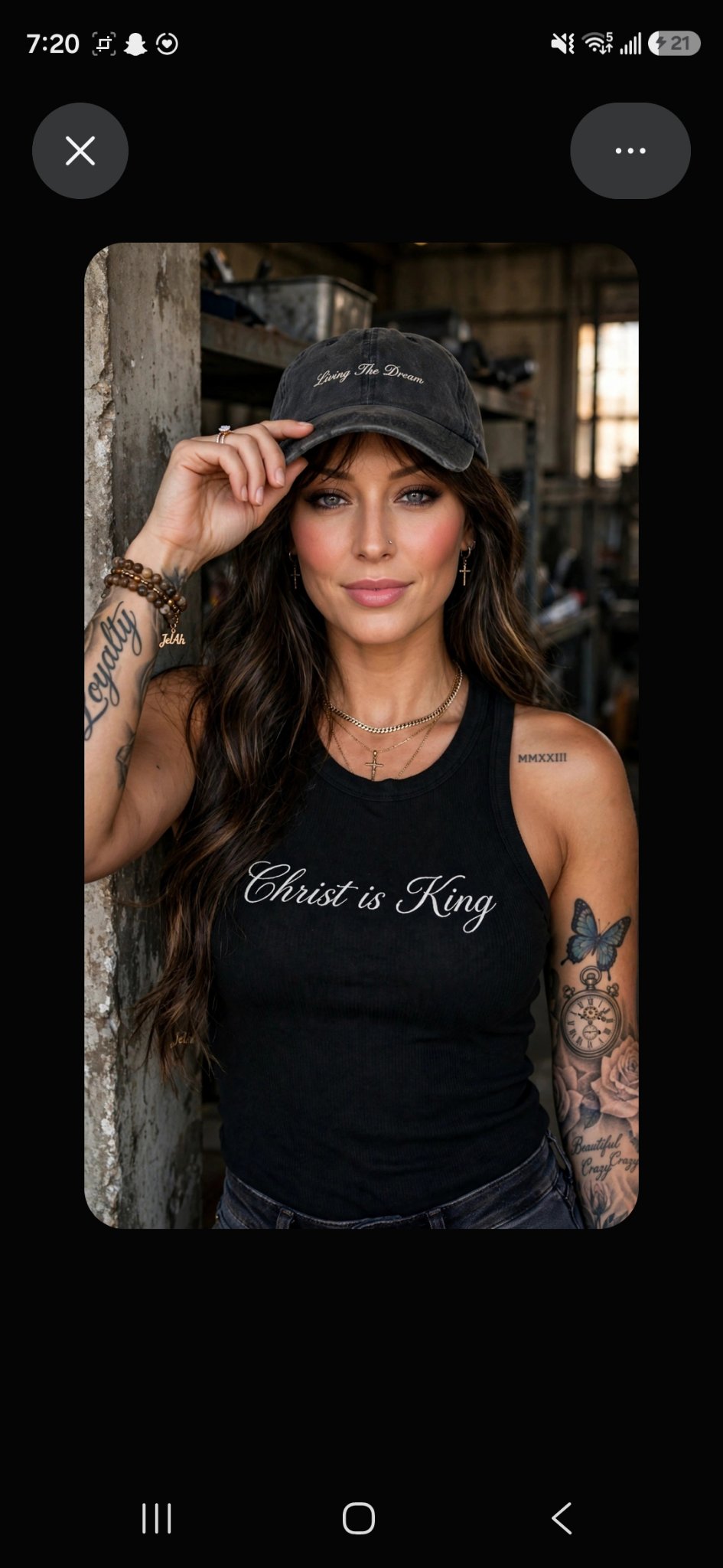 Jelah wearing the Christ Is King tank top and a Living The Dream cap, adjusting the cap